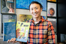 David Hu holding two popular science books he's authored.